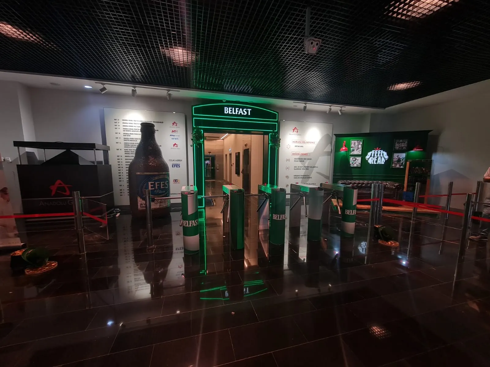 Exhibition Stand — A dark green exhibition stand with an illuminated arch entrance, as built.
